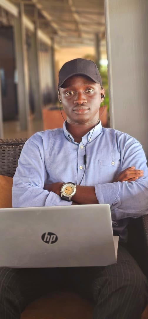 Abdulmumin working on a laptop